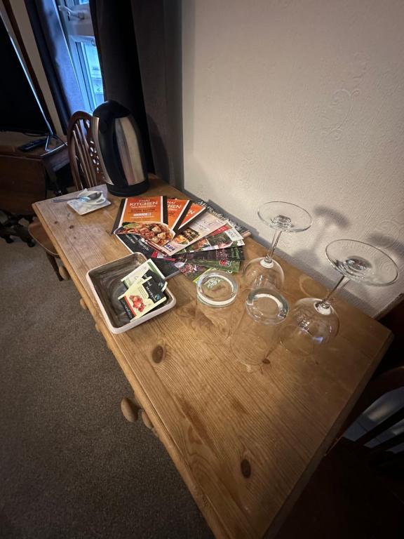 Wooden side table with kettle, glasses and local guides