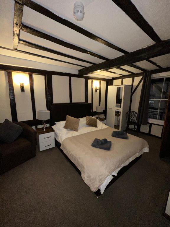 Double bed with sofa and wardrobe in characterful beamed room