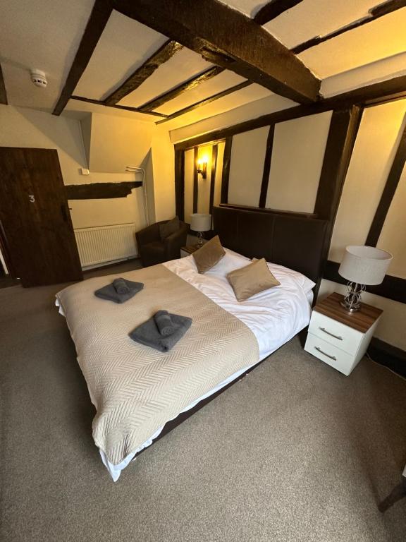 Double bed and bedside lamps under timber-beamed ceiling